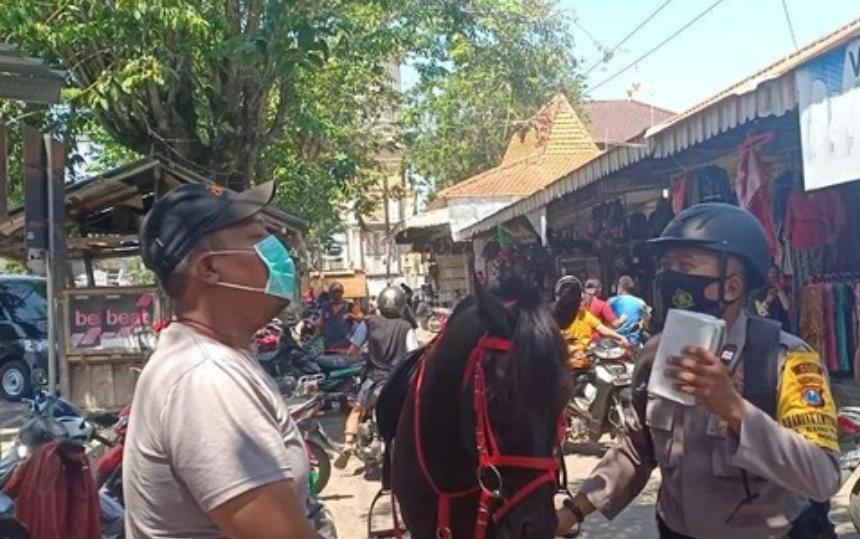 Petugas polisi saat menunggang kuda sosialisasi masker