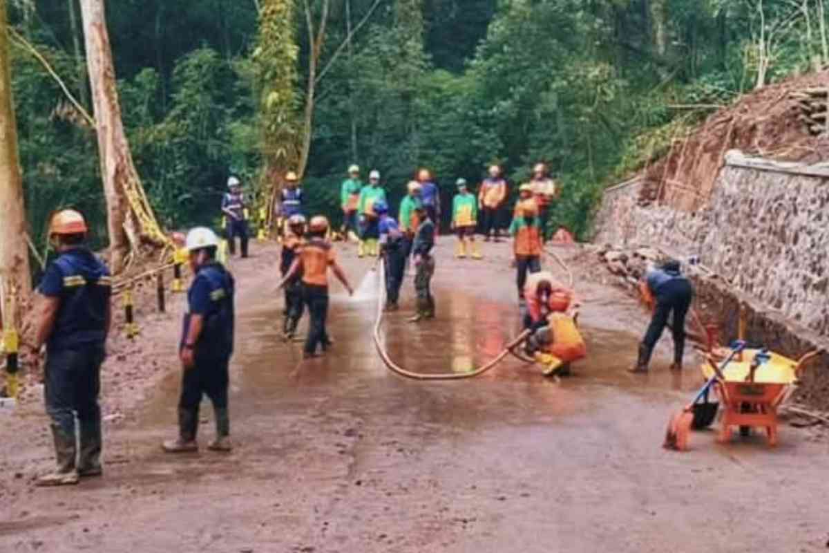 Petugas membersihkan jalur Pacet Cangar pasca longsor di Mojokerto
